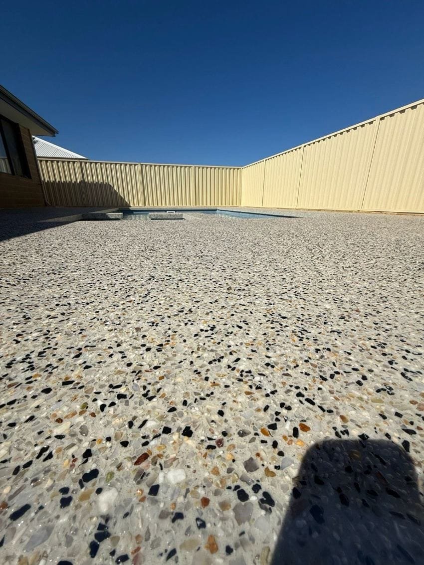Exposed aggregate pool surround under a clear blue sky